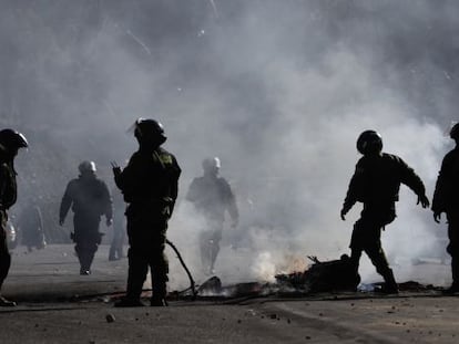 Polic&iacute;as apagan un fuego durante las protestas formadas en La Paz.