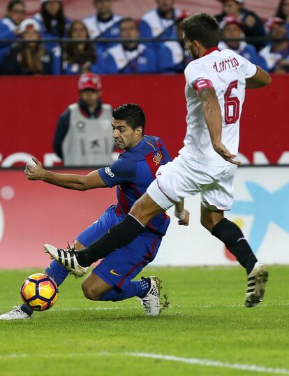 El defensa portugués del Sevilla Daniel Carriço (d) disputa un balón con el delantero uruguayo del F. C. Barcelona Luis Suárez.