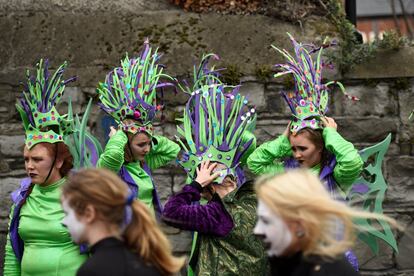 Participantes del desfile sujetan sus sombreros debido al viento en Dublín, Irlanda.