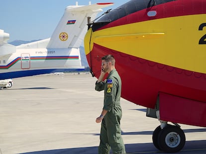 El capitán piloto Reinaldo Fernández Boyero, del 43 Grupo de la Fuerza Aérea, recibe instrucciones al teléfono en el aeropuerto de Dalaman (Turquía). Detrás un avión antiincendios de Azerbaiyán que también participa en las labores de extinción.