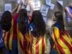 Varias estudiantes enganchan carteles en la pared de la Universidad de Barcelona durante el inicio de la "Maratón por la democracia".