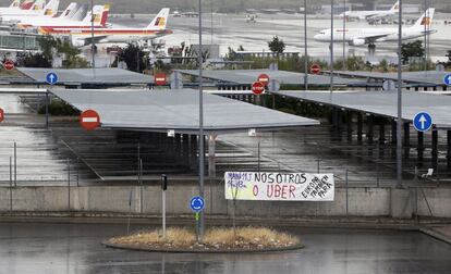 Ni en el aeropuerto, ni en las estaciones de tren y autobús, ni en los intercambiadores, ni por la calle; en Madrid no hay un solo taxi disponible y cientos de ciudadanos se desesperan tratando de llegar a su destino por otros medios. En la imagen, un cartel protesta contra la aplicación UBER en Barajas.