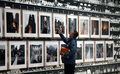 Un visitante toma una fotografía de la serie titulada 'Estudio de perspectiva', realizado entre 1995 y 2003, donde el artista levanta el dedo medio en contra de diferentes lugares alrededor del mundo, muchos de los cuales son icónicos en sus respectivos países por ser de gran interés turístico.