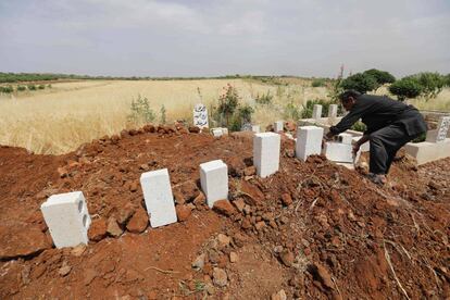 Un sirio coloca ladrillos sobre las tumbas de cinco civiles muertos en bombardeos sobre el poblado de Kafr Aweid, en la provincia de Idlib.