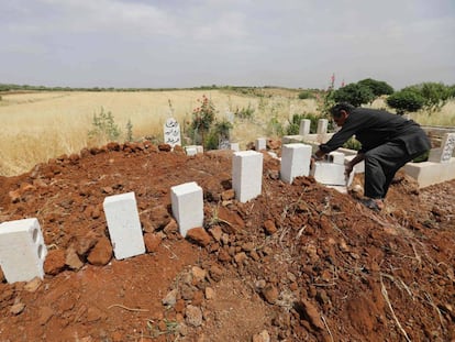 Un sirio coloca ladrillos sobre las tumbas de cinco civiles muertos en bombardeos sobre el poblado de Kafr Aweid, en la provincia de Idlib.