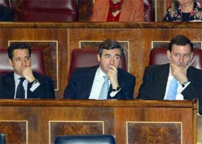 Los diputados del grupo popular, Eduardo Zaplana y Ángel Acebes, y el secretario general del PP, Mariano Rajoy, durante el pleno del Congreso.