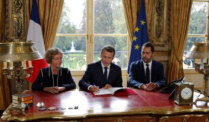 Emmanuel Macron firma las ordenanzas ante la prensa en su oficina en en el Elíseo, este viernes en París.