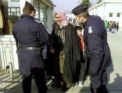 Dos policías revisan los documentos de un refugiado kurdo, ayer en Fréjus, al sur de Francia.