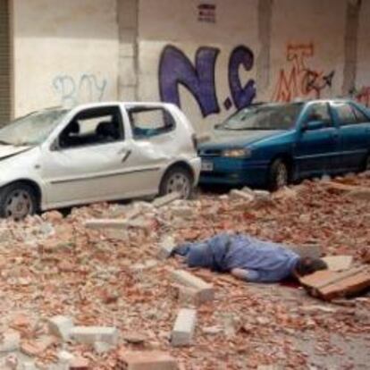 Uno de los fallecidos (i) rodeado por varias personas junto a otra de las víctimas (d), en la calle Galicia de Lorca