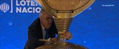 Captura de la emisión televisiva del sorteo de la Lotería de Navidad, en el momento en el que operario introduce manualmente una bola en el bombo. 