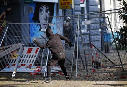Manifestante mascarado lança pedra contra a polícia durante protesto contra o G20. 