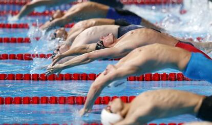 Ryyan Lochte, en el centro con el gorro negro y bañador rojo y negro, en la salida de la final de 200m espalda.