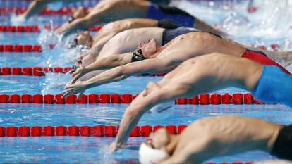 Ryyan Lochte, en el centro con el gorro negro y bañador rojo y negro, en la salida de la final de 200m espalda.