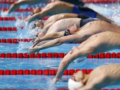 Ryyan Lochte, en el centro con el gorro negro y bañador rojo y negro, en la salida de la final de 200m espalda.