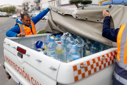 Dos voluntarios de protección civil durante el reparto de garrafas de agua en Pozoblanco.