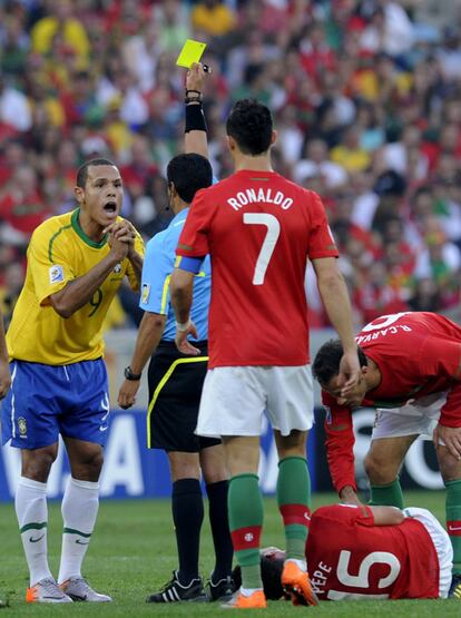 El arbitro mexicano saca una tarjeta amarilla al jugador brasileño Luis Fabiano.