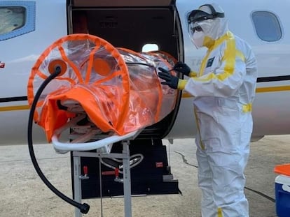 Profissional da saúde prepara maca especial para transporte de paciente com covid-19 em UTI aérea em meio à pandemia no Brasil.