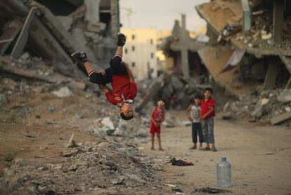 Un niño palestino hace piruetas entre las ruinas de la ciudad de Shejaia, en Gaza.