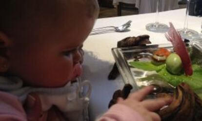 Una niña observa un plato en un restaurante.