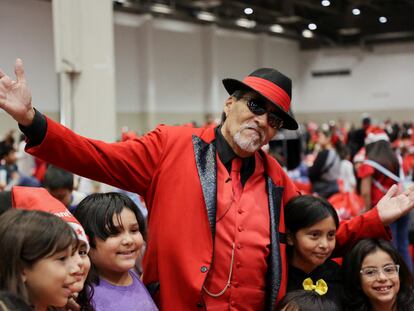 Richard Reyes caracterizado como Pancho Claus posa con niños en un evento navideño en Houston, Texas, el 16 de diciembre, 2023.