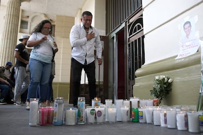 Dos personas rezan frente a un memorial  de Alejandro Arcos, alcalde de Chilpancingo asesinado en octubre pasado. 