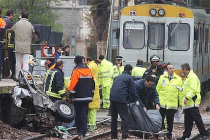 Efectivos del retén fúnebre retiran el cadáver del conductor del coche arrollado en Benimàmet.