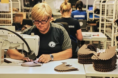 Una empleada de Görlitz recorta el cuero de unas sandalias.