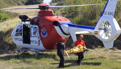 Miembros del equipo de rescate trasladan este domingo a la mujer fallecida al caer por un acantilado en Muskiz.