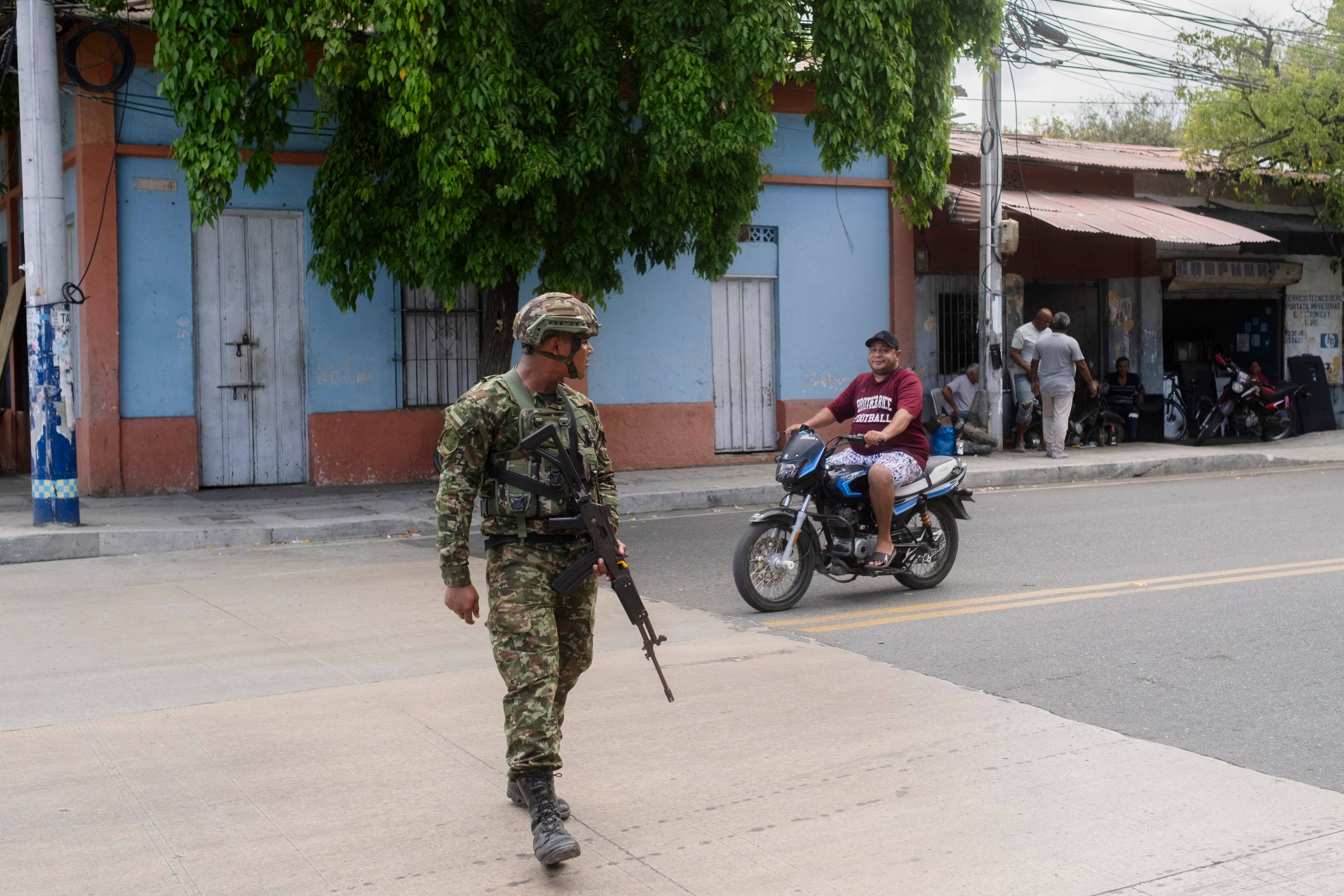 Un soldado del Ejército patrulla una calle mientras algunos establecimientos comienzan a retomar sus actividades, en Santa Marta, este jueves.