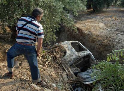 Un vecino de Valdeastillas (Jaén) observa el coche en el que viajaba la pareja fallecida.