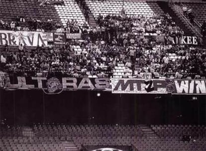 Los hinchas del Olympique, tras la pancarta con una calavera que originó el conflicto con la policía.