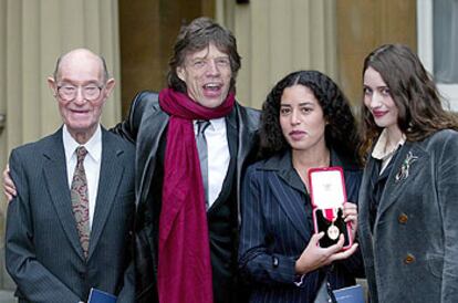 Mick Jagger, con su padre, Joe, de 92 años, y sus hijas Elizabeth y Karis, que muestra la condecoración.