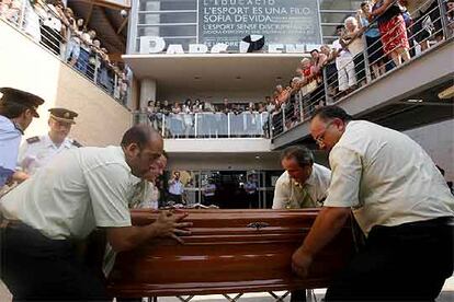 Personal funerario traslada el ataúd de uno de los fallecidos en el accidente en el polideportivo de Torrent.