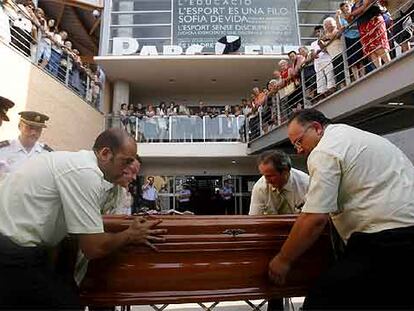 Personal funerario traslada el ataúd de uno de los fallecidos en el accidente en el polideportivo de Torrent.