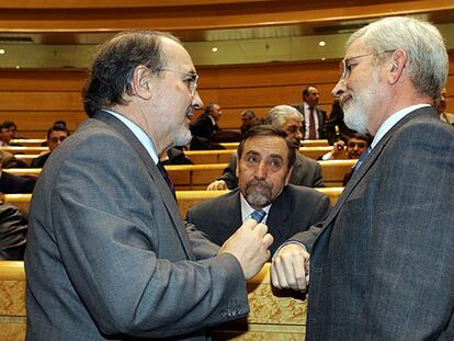 El vicepresidente económico, Pedro Solbes (izquierda), charla con los senadores Juan Barranco y Joan Lerma.