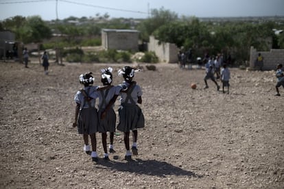 Tres colegialas caminan por el pavimento rocoso en los alrededores del colegio evangélico de Betsheda, en Canaan, durante el recreo. Los habitantes de esta localidad han invertido su propio dinero y esfuerzo en reconstruir la ciudad así que se muestran muy abiertos a planear y renovar los espacios urbanos.