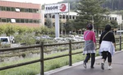 Dos mujeres caminan junto a la factoría de la empresa Fagor en la localidad guipuzcoana de Mondragón.