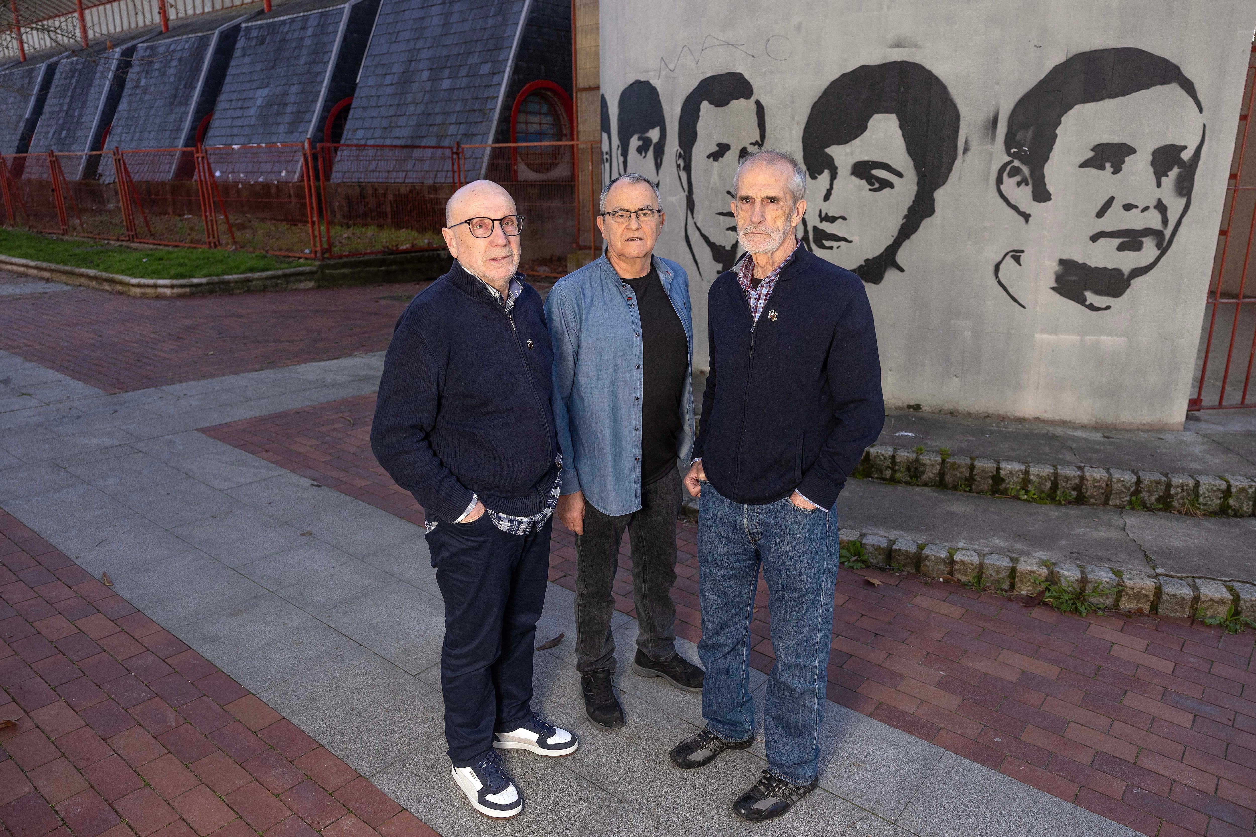 Los tres testigos de la matanza que se produjo el tres de marzo de 1976 junto a los rostros de los 5 asesinados, en una de las paredes de la iglesia de San Francisco de Asis, en el barrio de Zaramaga, en Vitoria.