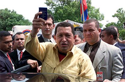 El presidente Hugo Chávez muestra un ejemplar de la Constitución venezolana ayer en Porto Alegre.