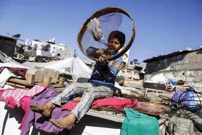 Un niño palestino juega bajo el sol con un tamiz de harina en el campo de refugiados de Jabalia (Franja de Gaza).