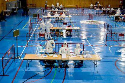 Miembros de las mesas con el traje de protección EPI en el Pabellón Municipal de Deportes del barrio de Santa Eugènia de Girona