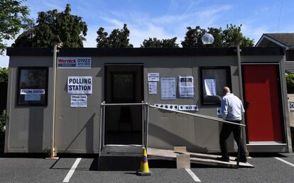 Un hombre camina hacia un centro de votación instalado en una cabina móvil en Hednesford (Reino Unido), este jueves.