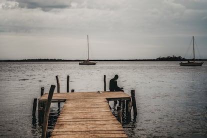 Un hombre descansaba sobre las tablas de un muelle en el puerto de Ndangane, en Senegal, en agosto.