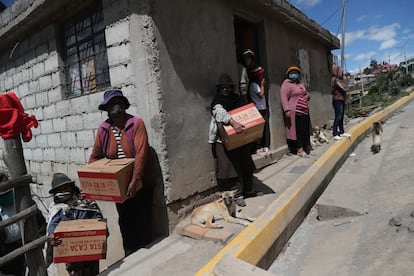 Vecinos de Quito, Ecuador, retiran cajas con comida aportadas por el gobierno durante el confinamiento decretado contra la pandemia, el 27 de mayo de 2020.