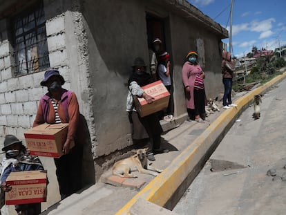 Vecinas de las afueras de Quito reciben las cajas de alimentos repartidas por el Gobierno durante la cuarentena.