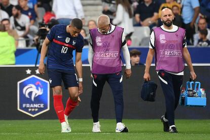 Mbappé se señala la rodilla lesionada ante los médicos de Francia, este viernes en París.
