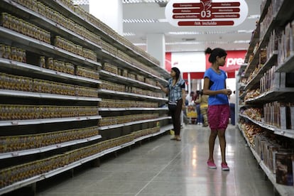 Los clientes caminan por pasillos prácticamente vacíos. En la imagen se observa cómo el mismo producto se coloca en una sola fila para dar la sensación de que los estantes están llenos. La imagen es de un supermercado en Caracas.