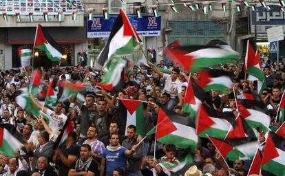 Palestinos agitan banderas en una plaza de Ramala donde se transmite el discurso de Abbas ante la Asamblea General de la ONU.