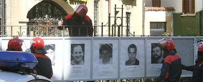 Agentes de la Ertzaintza retiran los carteles de etarras en Mondragón.