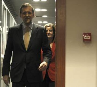 El presidente del Gobierno, Mariano Rajoy, seguido por la ministra de Empleo, Fátima Báñez, a su llegada a la rueda de prensa que ha ofrecido hoy en el Palacio de la Moncloa.